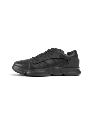 Black sneakers made of leather with a textured finish, featuring a rounded toe, laces, and a thick rubber sole for support.