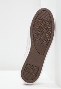 Suela de zapatilla rosa con un patrón de banda de rodadura geométrico, acentos laterales blancos y un logotipo. El material parece ser goma con una superficie texturizada.