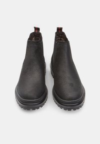 Mustad musta värvi ankle boots sileda nahk üleosaga, elastsete külgpaneelidega ja tekstuurse kummitaldaga. Seljaosas punane tõmblukk, mis lihtsustab jalga panemist.