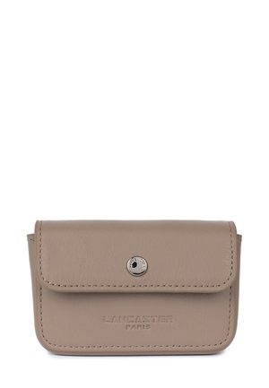 Portafoglio in pelle beige con chiusura a patta, bottone a pressione argentato e logo "LANCASTER PARIS" impresso sul fronte. Presenta cuciture ordinate.