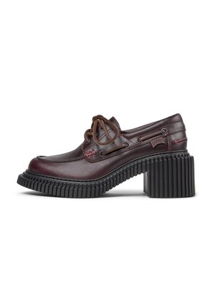 Brown leather shoe with a rounded toe and brown laces. Features a thick black ribbed heel and contrasting red stitching detail.