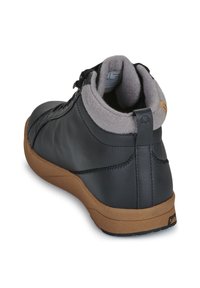 Scarpa alta in pelle nera con colletto in felpa grigia e suola in gomma marrone. Presenta un design cucito e una linguetta sul tallone per una facile calzata.