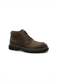 Botas chukka de cuero marrón con punta redonda, diseño de cordones, cuello acolchado y suela de goma contrastante. Detalles de costura sutiles.