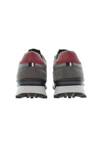 Pár šedých tenisek s červenými akcenty na patách a bílými mezipodešvemi, zobrazených ze zadní strany na bílém pozadí.