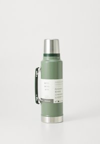 Green stainless steel vacuum flask with a silver lid and green handle, displaying temperature retention details on the label.