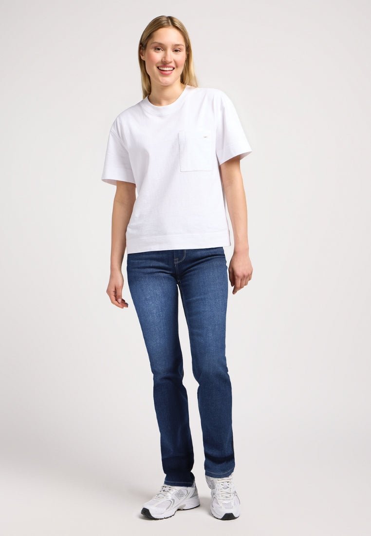 Witte katoenen t-shirt met korte mouwen en borstzak, gecombineerd met donkerblauwe jeans en witte sportschoenen. Eenvoudig en casual ontwerp.