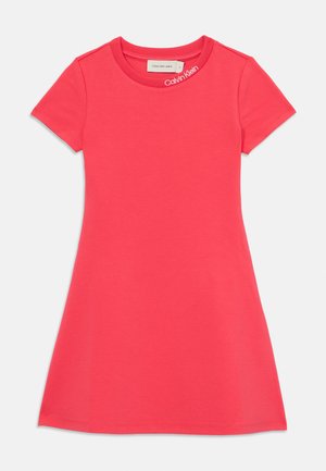 Rózsaszín, rövid ujjú ruha kerek nyakkivágással, pamutból készült. Enyhe A-vonalú fazonnal rendelkezik, és egy apró logó található a galléron.