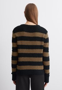 Zwart en bruin gestreepte trui van een textuurachtige, fuzzy stof. Heeft lange mouwen en een ronde hals. Zichtbare horizontale strepen.