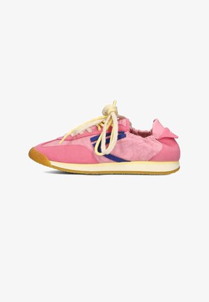 Scarpa da ginnastica rosa con dettaglio laterale a zigzag blu, lacci beige legati a fiocco e suola marrone chiaro su sfondo bianco.