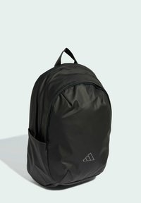 Zaino nero realizzato in materiale liscio e resistente. Presenta una forma arrotondata, una tasca frontale con zip e una tasca laterale. Include una maniglia superiore.