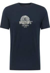 Sötétkék pamut póló kerek nyakkal, elöl világosszürke kör alakú logóval és "MUSTANG JEANS COMPANY" felirattal.
