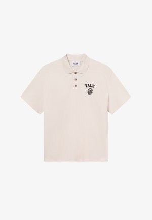 Krémové polo tričko s krátkym rukávom a klasickým golierom, so zapínaním na tri gombíky a logom Yale so znakom bulldoga na ľavej hrudi.