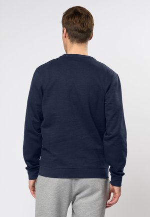 Tengerészkék pulóver kerek nyakkal és hosszú ujjakkal, puha pamut anyagból készült; bordázott mandzsettákkal és szegéllyel rendelkezik.