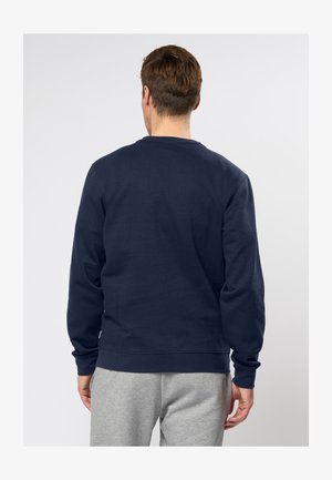 Tengerészkék pulóver kerek nyakkal és hosszú ujjakkal, puha pamut anyagból készült; bordázott mandzsettákkal és szegéllyel rendelkezik.