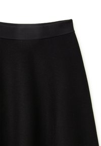 Schwarzer A-Linienrock mit einem glatten, elastischen Bund, gerippter Textur und knielangem Design. Keine sichtbaren Muster oder Akzente.