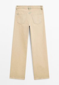 Jeans beige a vita alta con gamba larga e una texture liscia. Presentano due tasche posteriori e un orlo pulito. Cuciture a contrasto lungo la vita e le tasche.