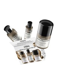 L'Oréal Absolut Repair Molecular Hair Kit som innehåller fyra flaskor med svarta lock, ljusbrun vätska och en reklamförpackning med produktinformation.