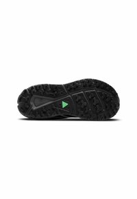 Suela de zapato deportivo negro con una superficie de goma texturizada, un patrón de suela agresivo y un acento verde distintivo.