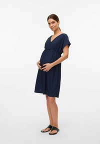 Abito premaman blu navy con scollo a V e maniche corte, caratterizzato da dettagli in pizzo e una cintura in vita per una vestibilità regolabile.