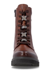 Botte en cuir marron à lacets noirs avec des breloques décoratives en forme de papillon et d’anneau ornées de strass à l’avant.