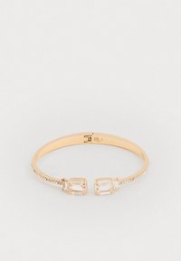 Arany színű bangle karkötő, két téglalap alakú átlátszó kristállyal, valamint egy texturált szalaggal, amely az egyik oldalon kis átlátszó gyöngyökkel van díszítve.