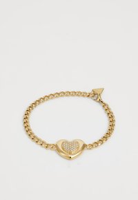 Bracelet en chaîne dorée avec un centre en forme de cœur orné de cristaux transparents. Fermoir en forme de homard avec une étiquette triangulaire comme accent.