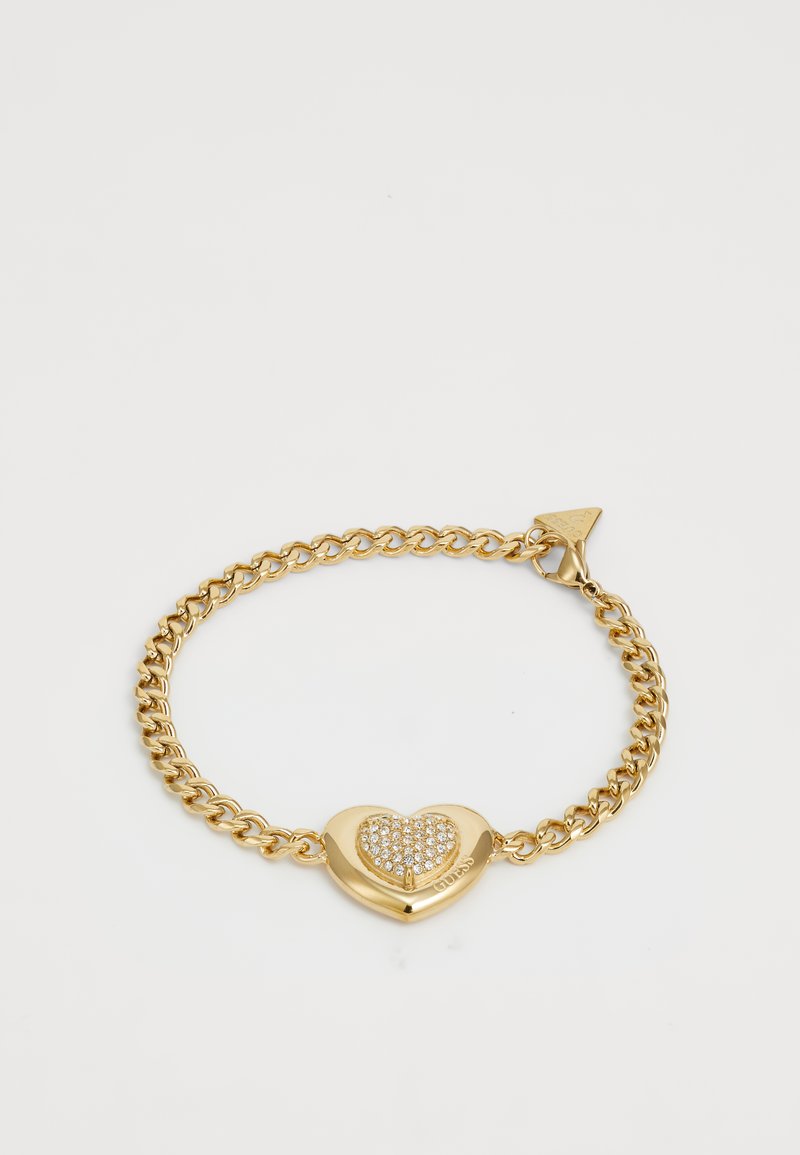 Bracelet en chaîne dorée avec un centre en forme de cœur orné de cristaux transparents. Fermoir en forme de homard avec une étiquette triangulaire comme accent.
