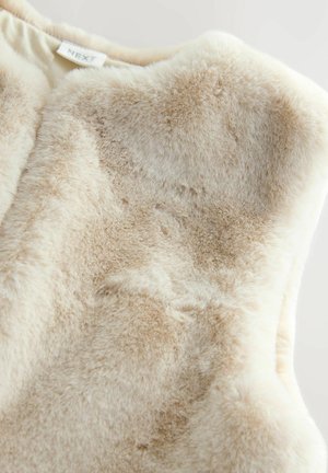 Weiches beige Kunstfellstoff mit einem Etikett, das NEXT zeigt, und einer Nahaufnahme der Textur und des plüschigen Materials.
