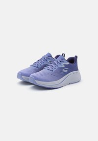 Baskets de sport violettes avec une tige en maille respirante, un laçage, une semelle rembourrée et une bande d'accent blanche sur le côté.