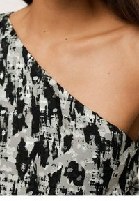 Asymmetrical dress featuring a black and gray abstract pattern, textured fabric with subtle shine, and a smooth neckline.