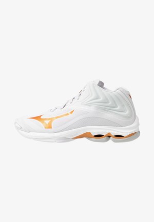 Zapatilla deportiva blanca de caña alta con detalles naranjas, paneles de malla y suela acolchada diseñada para deportes o correr.