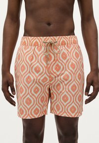 Shorts de bain à motifs présentant un design de vagues pêche et crème avec de petits accents de crânes, taille élastique et fermeture à cordon.