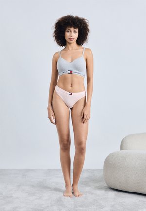 Šedý bralet s logem a světle růžové kalhotky. Bralet má nastavitelné ramínka; obě části mají měkkou, hladkou texturu.
