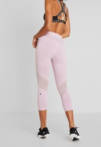 Rosa träningsleggings har en blandning av fasta och meshpaneler, med hög midja och en subtil logotypdetalj på underbenet.