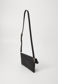 Black textured crossbody bag with embossed pattern, adjustable strap, and gold hardware accents. Slim, rectangular shape. Elegant design.