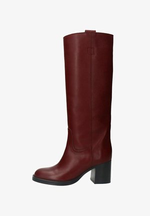 Lange, rode leren laarzen met een gladde textuur, blokhak en gebogen stiksel op de schacht. Eenvoudig ontwerp, geen zichtbare hardware.