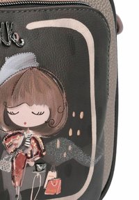 Borsa a tracolla in pelle nera con illustrazione di una donna in stile cartoon, dettagli metallici e una cornice grigia. Include il design di sacchetti per la spesa e una borsa.