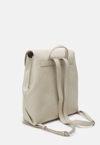 Beżowy plecak ze skóry o gładkiej fakturze, z tłoczonym wzorem logo, regulowanymi paskami i górnym uchwytem dla większej wszechstronności.