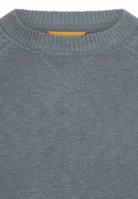 Szary dzianinowy sweter z prążkowanym okrągłym dekoltem, z teksturowanym wzorem i widoczną pomarańczową metką przy kołnierzu.