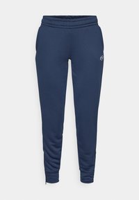 Tamsiai mėlynos sportinės kelnės, pagamintos iš švelnios medžiagos, su elastingu juosmeniu, šoninėmis kišenėmis ir užtrauktukais ant kulkšnių, leidžiančiais reguliuoti ilgį.