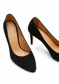 Černé semišové lodičky na vysokém podpatku s špičatými špičkami, koženými stélkami a minimálními švy. Elegantní design s štíhlým, zúženým podpatkem.