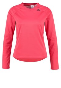 Maglietta sportiva a maniche lunghe di colore rosa brillante, realizzata in tessuto traspirante. Presenta un collo rotondo e un logo discreto sulla parte superiore sinistra del petto.