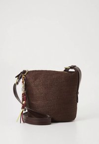 Bolso bandolera marrón tejido con correa ajustable de cuero y borla trenzada decorativa con detalles metálicos, sobre un fondo blanco.