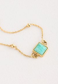 Gold chain bracelet featuring a square turquoise stone pendant, smooth texture, with round beads along the chain and a simple clasp.