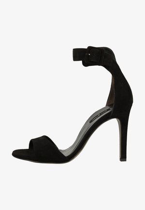 Czarne zamszowe sandały na wysokim obcasie z otwartym palcem, paskiem wokół kostki i smukłym obcasem typu stiletto. Gładka tekstura i minimalistyczny design.