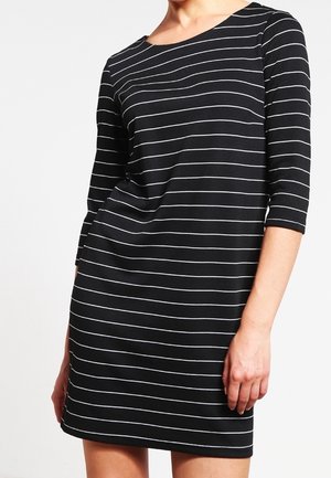 Abito nero con righe orizzontali bianche, maniche a tre quarti, scollatura rotonda e vestibilità rilassata. Tessuto morbido con una texture elastica.