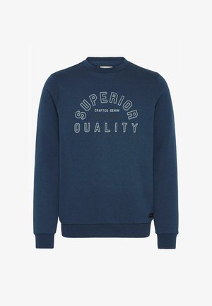 Tumedat sinise värvuse ja tekstureeritud kangaga dressipluus, millel on ümar kaelus ja soonikkäised. Ees on valgest kirjas "SUPERIOR QUALITY".