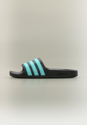Black slide sandal with three turquoise stripes on the strap, textured rubber material, flat sole, and embossed logo on the side.