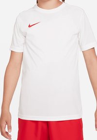 Bílý sportovní tričko Nike se červeným logem swoosh, kulatým výstřihem a krátkými rukávy, vyrobené z hladké, lehké tkaniny.