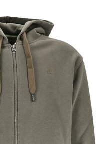 Felpa con zip di colore verde oliva, caratterizzata da una consistenza morbida, con cappuccio regolabile tramite cordino e un piccolo logo decorativo sul petto.